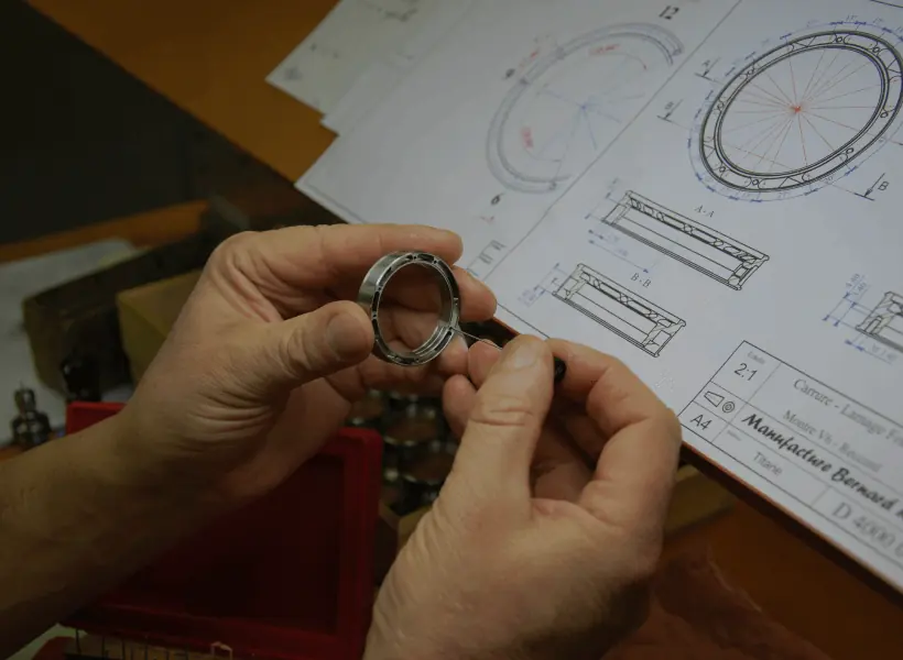 Mains tenant une carrure usinée au-dessus de son plan technique, au cartouche de la Manufacture Bernard Richards