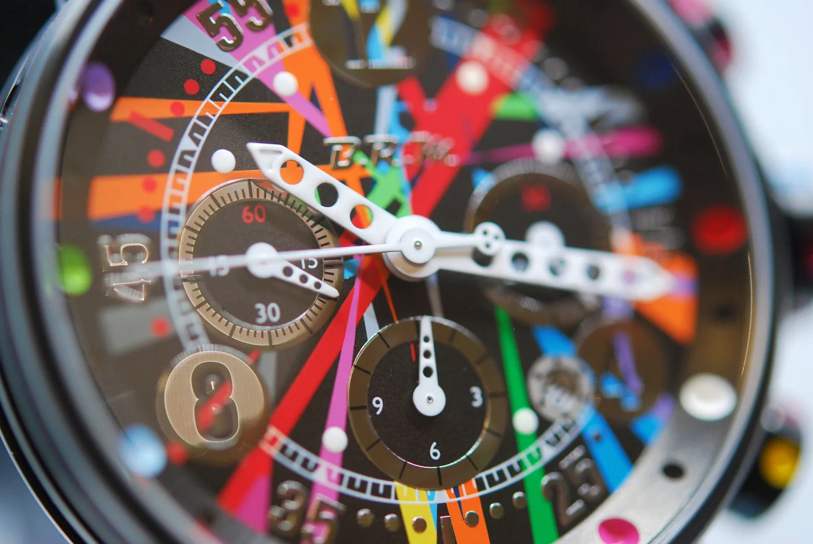Cadran chronographe de la V12-44 Titane Art Car en gros plan : faisceaux de couleurs, compteurs, aiguilles perforées
