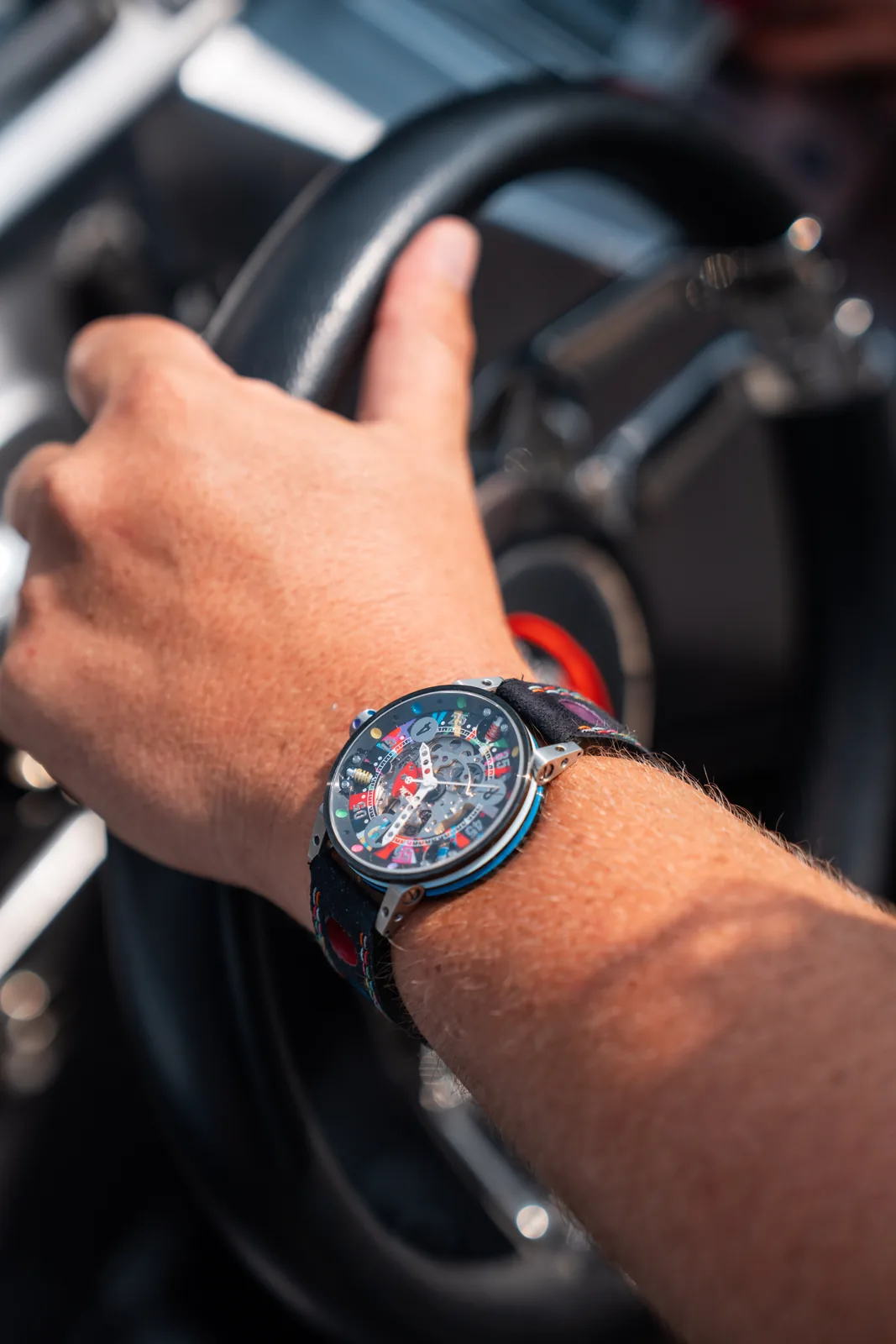 Montre Art Car au poignet, main sur le volant d'un bateau de course