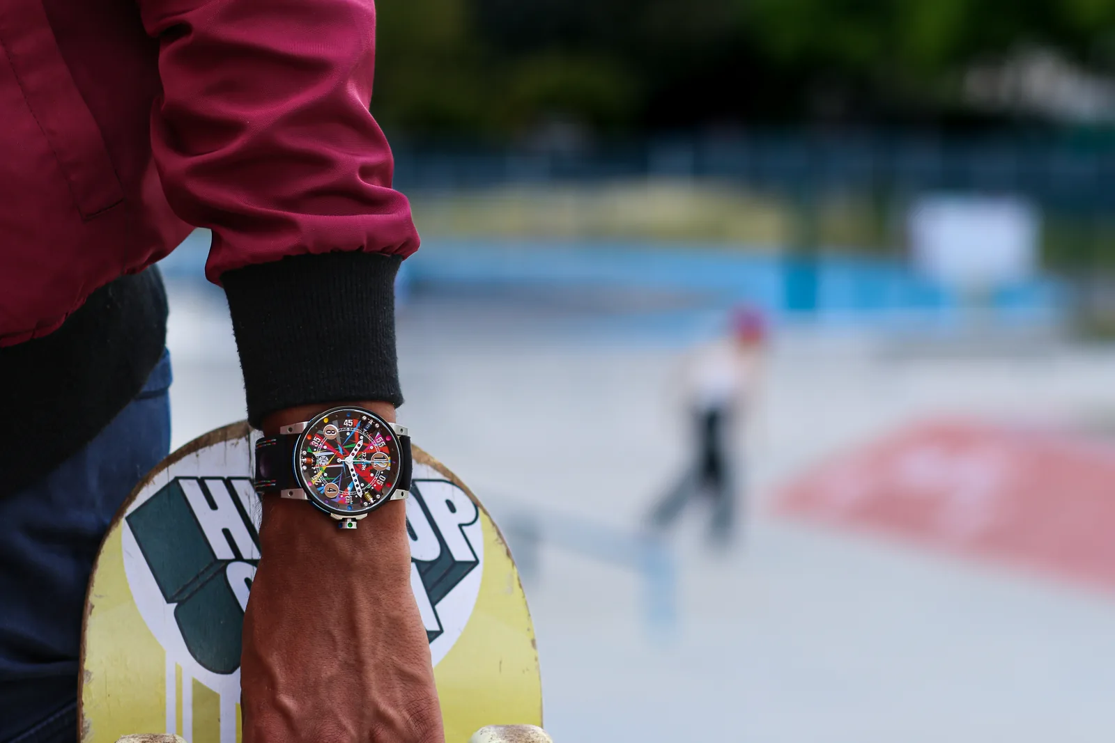 Montre Art Car au poignet, main tenant une planche de skate