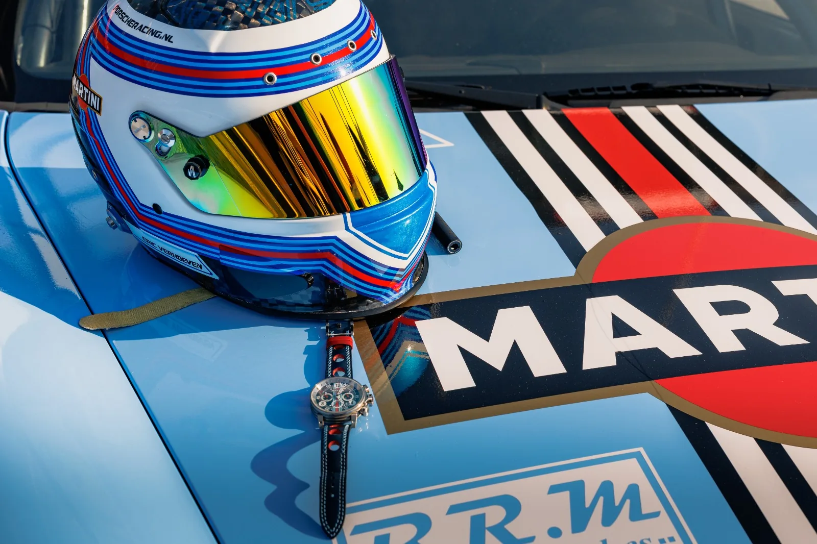 Pilotenhelm und B.R.M Chronograph auf der Motorhaube eines Rennwagens in Martini Racing Lackierung