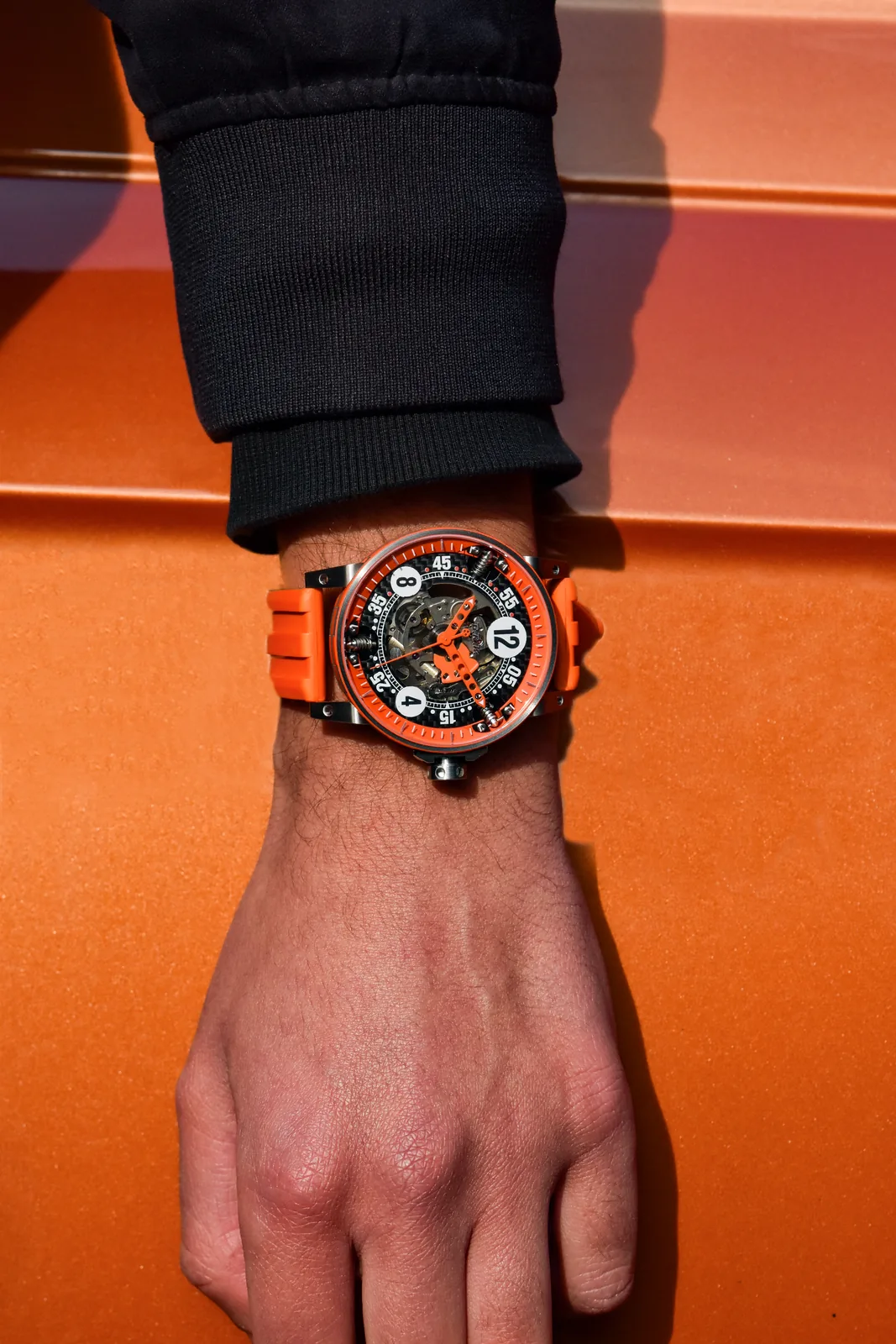 V6-44-SA Cercolor squelette orange au poignet, main sur carrosserie orange