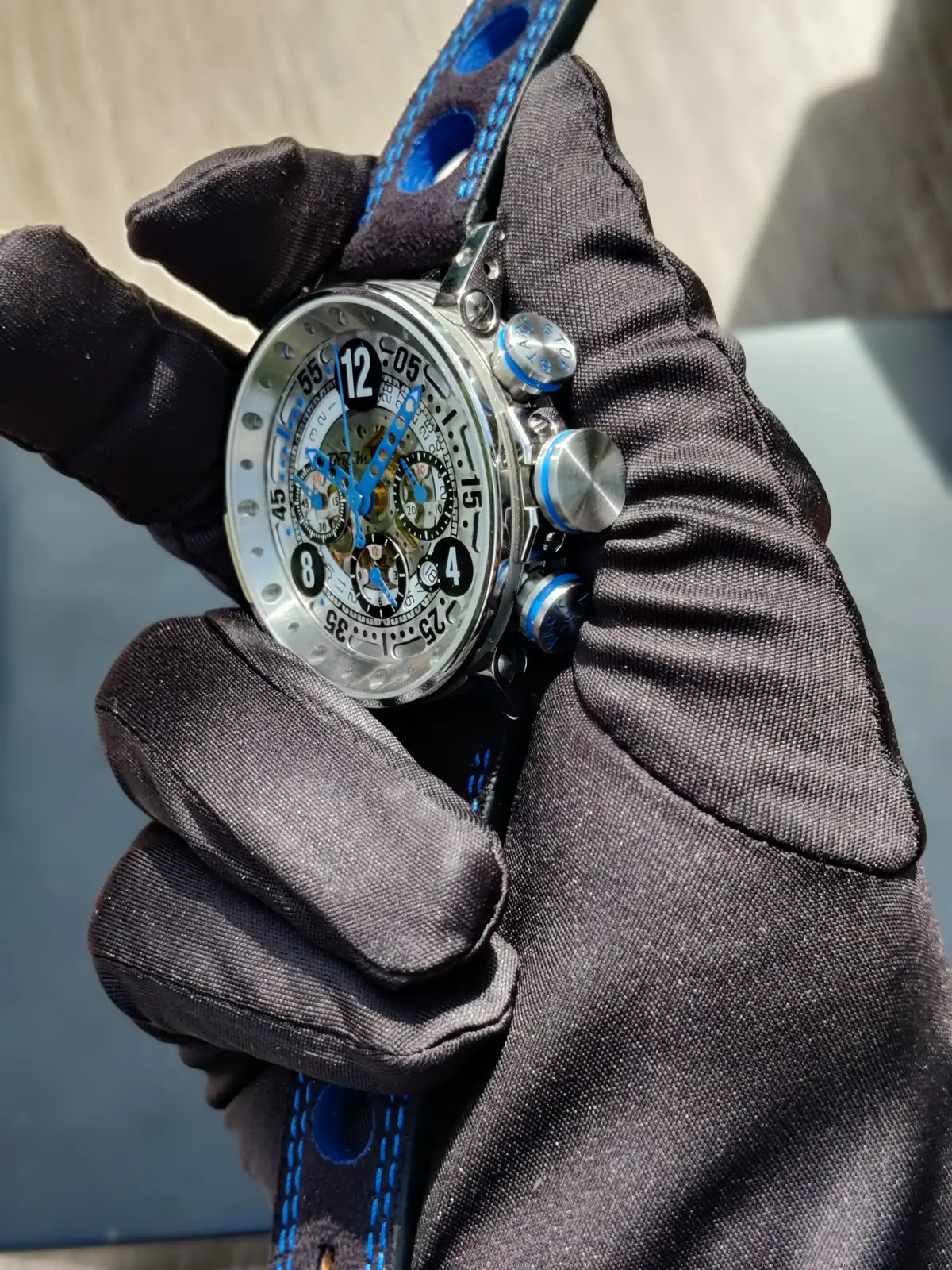 V12-44 squelette bleu tenue en main gantée, cadran ajouré et compteurs